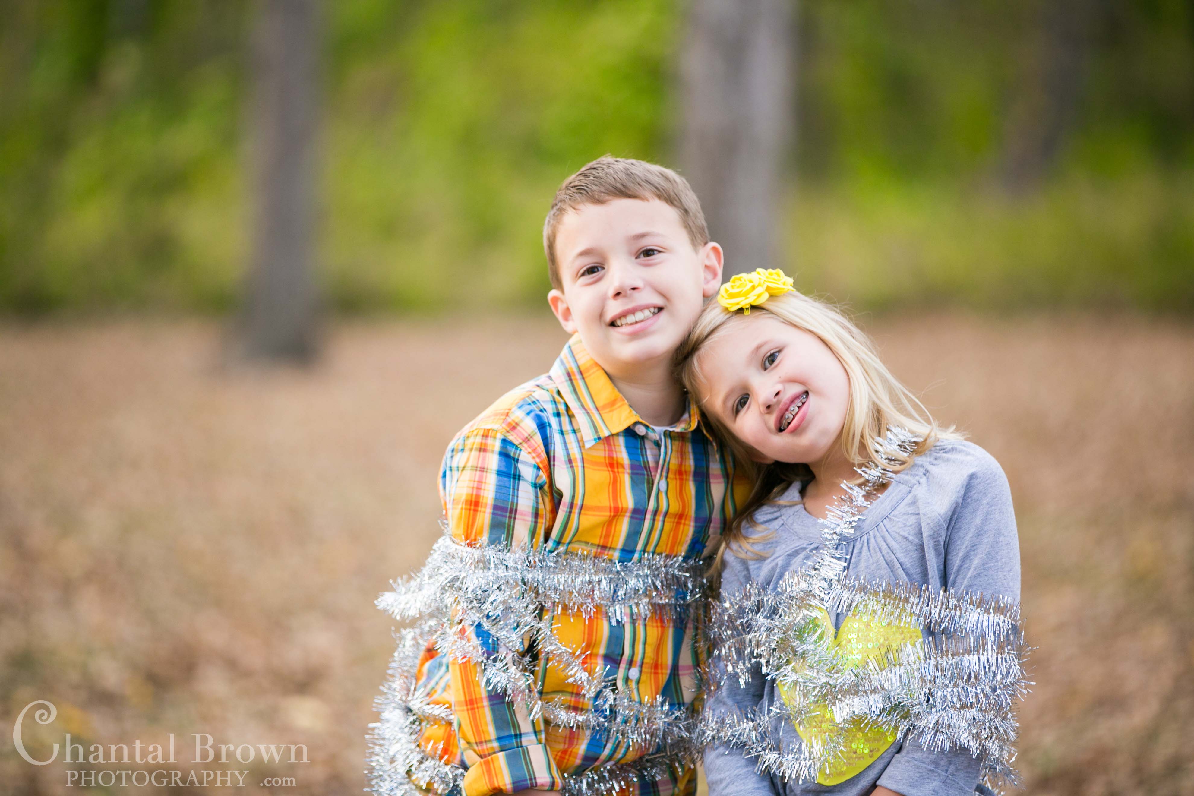 Richardson-Breckinridge-Park-16 Playing and having fun with Christmas decorations in pretty fall autumn color field covered with leaves Children Portrait at Breckinridge Park in Richardson Texas